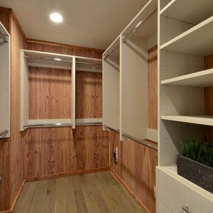 Idée de décoration pour un petit dressing marin neutre avec un placard à porte plane, des portes de placard en bois clair et un sol en bois brun.