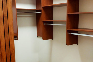 Imagen de armario vestidor unisex vintage extra grande con armarios con paneles lisos, puertas de armario de madera oscura, moqueta y suelo gris