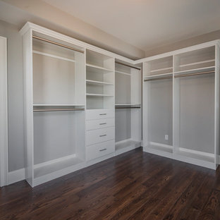 Example of a small transitional gender-neutral medium tone wood floor and brown floor walk-in closet design in Columbus