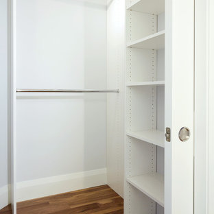 Idee per una piccola cabina armadio unisex classica con ante lisce, ante bianche e pavimento in legno massello medio