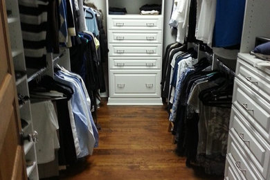 Walk-in closet - mid-sized traditional men's dark wood floor and brown floor walk-in closet idea in Jacksonville with raised-panel cabinets and white cabinets