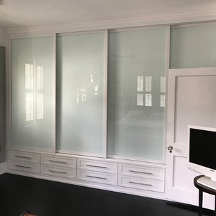 Immagine di un piccolo armadio o armadio a muro unisex contemporaneo con ante in stile shaker, ante bianche, pavimento in laminato e pavimento nero