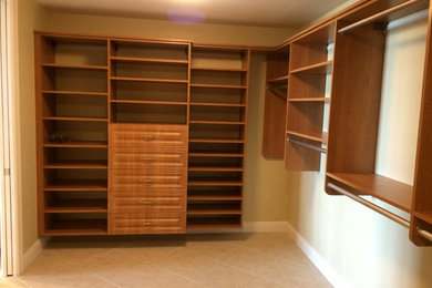 Walk-in closet - large traditional gender-neutral ceramic tile and beige floor walk-in closet idea in Miami with raised-panel cabinets and medium tone wood cabinets