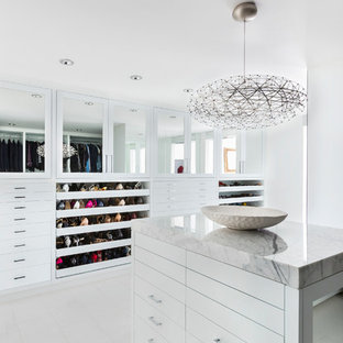 Exemple d'un grand dressing rétro neutre avec un placard à porte plane et des portes de placard blanches.