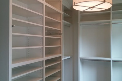Diseño de armario vestidor unisex clásico renovado grande con armarios abiertos, puertas de armario blancas y suelo de madera oscura