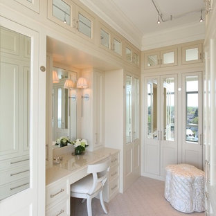 Cette image montre un grand dressing room design neutre avec un placard avec porte à panneau encastré, des portes de placard blanches et moquette.