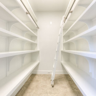 Ejemplo de armario vestidor unisex, moderno, de tamaño medio, con armarios abiertos, puertas de armario blancas, suelo de cemento y suelo beige