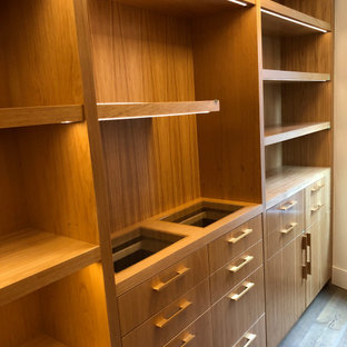 Esempio di una grande cabina armadio moderna con ante lisce e ante marroni