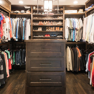 Modelo de vestidor unisex, tradicional renovado, de tamaño medio, con armarios estilo shaker, puertas de armario de madera en tonos medios y suelo de madera oscura