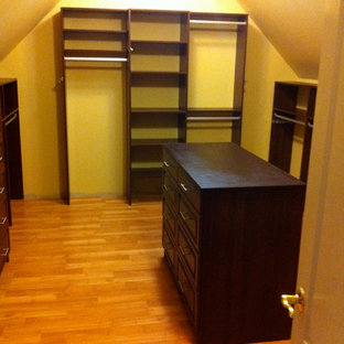 Foto di una grande cabina armadio unisex chic con ante con bugna sagomata, ante in legno bruno, parquet chiaro e pavimento beige