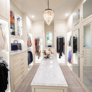 Klassisk inredning av ett stort walk-in-closet för kvinnor, med luckor med profilerade fronter, vita skåp, heltäckningsmatta och beiget golv