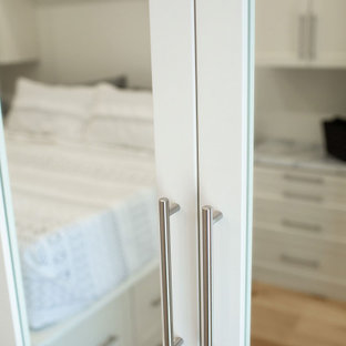 Ispirazione per una cabina armadio unisex chic di medie dimensioni con ante in stile shaker, ante beige, pavimento in legno massello medio e pavimento giallo