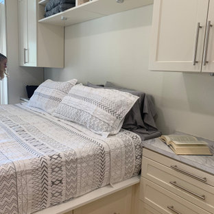 Immagine di una cabina armadio unisex classica di medie dimensioni con ante in stile shaker, ante beige, pavimento in legno massello medio e pavimento giallo