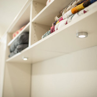 Foto di una cabina armadio unisex classica di medie dimensioni con ante in stile shaker, ante beige, pavimento in legno massello medio e pavimento giallo