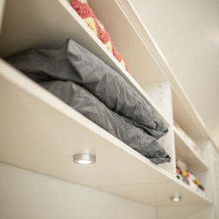 Foto di una cabina armadio unisex tradizionale di medie dimensioni con ante in stile shaker, ante beige, pavimento in legno massello medio e pavimento giallo