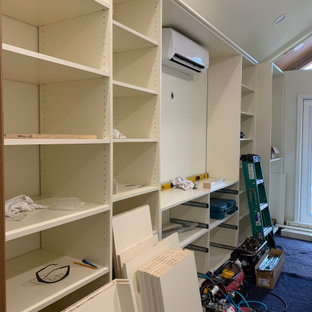 Esempio di una cabina armadio unisex chic di medie dimensioni con ante in stile shaker, ante beige, pavimento in legno massello medio e pavimento giallo