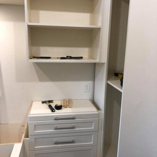 Foto di una cabina armadio unisex chic di medie dimensioni con ante in stile shaker, ante beige, pavimento in legno massello medio e pavimento giallo