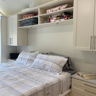 Foto di una cabina armadio unisex classica di medie dimensioni con ante in stile shaker, ante beige, pavimento in legno massello medio e pavimento giallo
