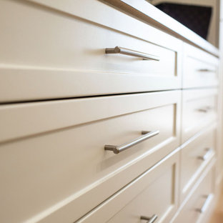 Idee per una cabina armadio unisex chic di medie dimensioni con ante in stile shaker, ante beige, pavimento in legno massello medio e pavimento giallo