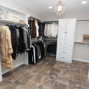 Foto di una cabina armadio unisex stile shabby di medie dimensioni con ante con bugna sagomata, ante bianche, pavimento in ardesia e pavimento marrone