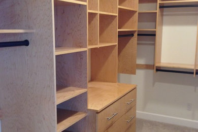 Mid-sized trendy men's carpeted walk-in closet photo in Seattle with medium tone wood cabinets