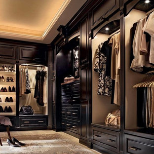 Foto de armario vestidor unisex, tradicional, extra grande, con puertas de armario de madera en tonos medios, suelo de baldosas de cerámica y armarios con paneles con relieve