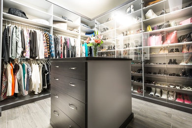 Diseño de armario vestidor unisex moderno de tamaño medio con armarios con paneles lisos, puertas de armario grises y suelo de baldosas de porcelana