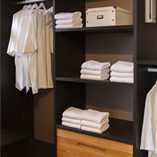 Idee per una cabina armadio unisex design di medie dimensioni con ante lisce, ante in legno scuro e pavimento nero
