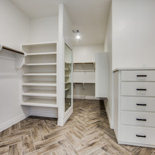 Foto de armario vestidor unisex, campestre, grande, con armarios con paneles lisos, puertas de armario blancas, suelo de baldosas de porcelana y suelo marrón