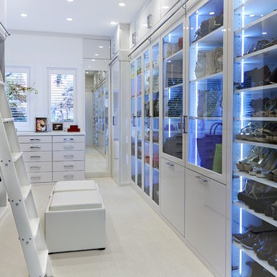 Trendy women's dressing room photo in Tampa with glass-front cabinets and white cabinets