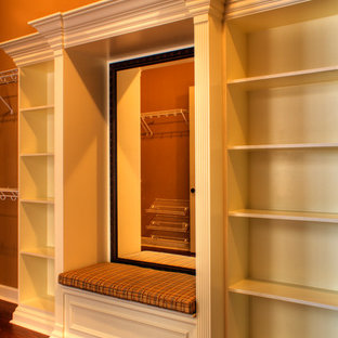 Idee per una cabina armadio unisex chic con ante con bugna sagomata, ante bianche e pavimento in legno massello medio