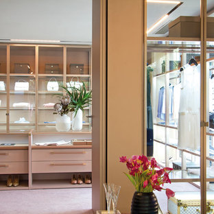 Cette image montre un dressing room design avec un placard à porte plane, moquette et un sol rose.