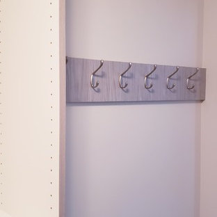 Esempio di una grande cabina armadio unisex moderna con ante lisce e ante grigie