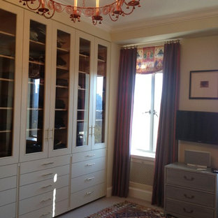 Imagen de vestidor de mujer, bohemio, de tamaño medio, con armarios tipo vitrina, puertas de armario beige, moqueta y suelo beige