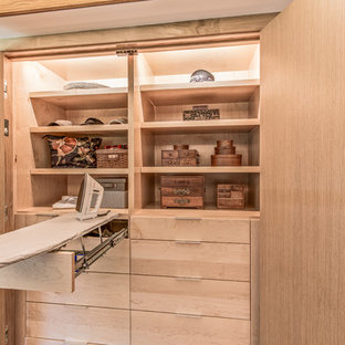 Diseño de armario unisex, retro, de tamaño medio, con armarios con paneles lisos, puertas de armario de madera clara, suelo de madera clara y suelo beige