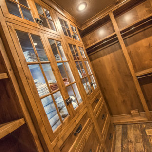 Idee per una cabina armadio unisex rustica di medie dimensioni con ante con riquadro incassato, ante in legno scuro e parquet scuro