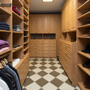 Immagine di una grande cabina armadio unisex american style con ante con bugna sagomata, ante in legno chiaro, pavimento in gres porcellanato e pavimento multicolore