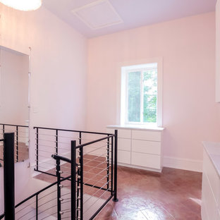 Idee per una cabina armadio per donna industriale con ante lisce, ante bianche e pavimento in terracotta