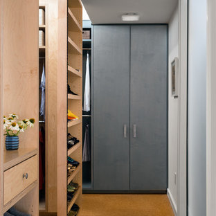 Idee per una grande cabina armadio unisex industriale con nessun'anta, ante in legno chiaro, pavimento in sughero e pavimento marrone