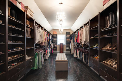 Inspiration for an expansive traditional walk-in wardrobe for women in Philadelphia with brown cabinets and dark hardwood flooring.