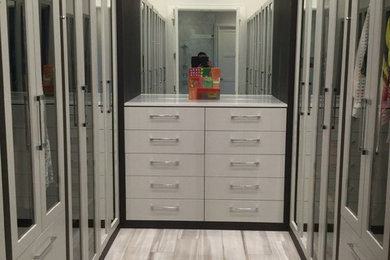Large transitional gender-neutral gray floor walk-in closet photo in Miami with flat-panel cabinets and white cabinets