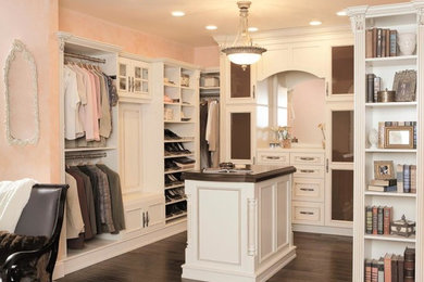 Diseño de armario vestidor de mujer romántico grande con armarios abiertos, puertas de armario blancas, suelo de madera oscura y suelo marrón