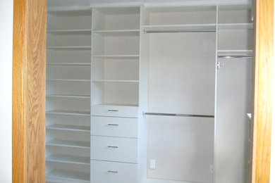 Large elegant walk-in closet photo in Los Angeles with flat-panel cabinets and white cabinets