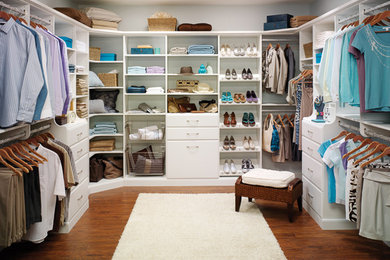 Foto de armario vestidor unisex clásico de tamaño medio con armarios con paneles lisos, puertas de armario blancas, suelo de madera oscura y suelo marrón