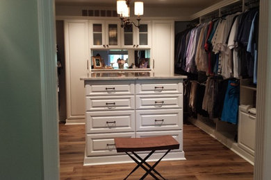 Design ideas for a large classic gender neutral walk-in wardrobe with raised-panel cabinets, white cabinets, medium hardwood flooring and brown floors.