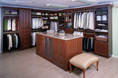 Large elegant gender-neutral light wood floor and beige floor walk-in closet photo in New York with raised-panel cabinets and dark wood cabinets