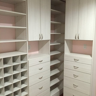 Ejemplo de armario vestidor de mujer, minimalista, de tamaño medio, con armarios con paneles lisos, suelo de madera en tonos medios y puertas de armario de madera clara