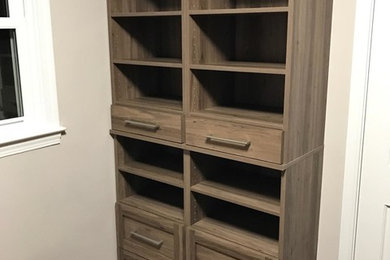 Example of a mid-sized transitional gender-neutral medium tone wood floor walk-in closet design in Atlanta with open cabinets and medium tone wood cabinets