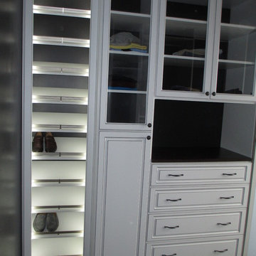 Closet w/lighted slant shoe shelves. glass doors, raised panel door & drawers