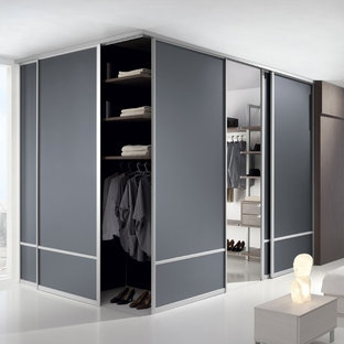 Imagen de armario vestidor unisex, moderno, grande, con armarios abiertos, puertas de armario de madera oscura y suelo blanco